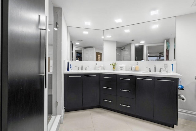 bathroom with a shower with door, vanity, and tile patterned floors