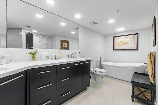 bathroom featuring vanity, a tub, and toilet