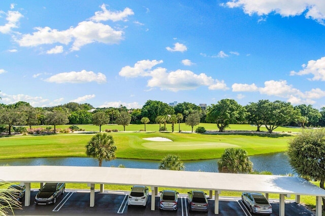 surrounding community with a water view and a lawn