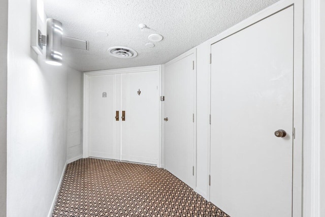 hallway with a textured ceiling