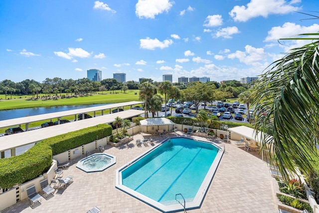 view of swimming pool featuring a patio area, a community hot tub, and a water view