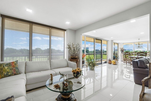 tiled living room featuring a notable chandelier and floor to ceiling windows