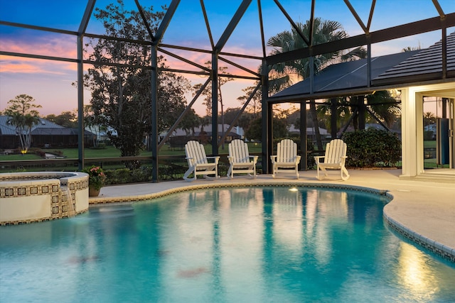 pool with a patio area and glass enclosure