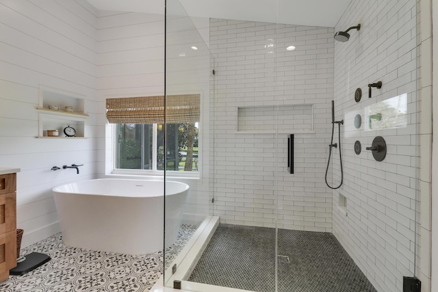 bathroom featuring tile patterned flooring, independent shower and bath, and lofted ceiling