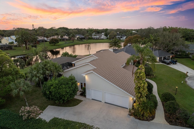 aerial view at dusk featuring a water view