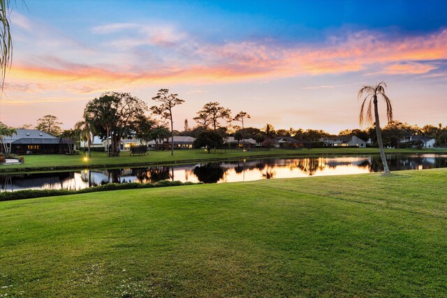 aerial view at dusk with a residential view and a water view