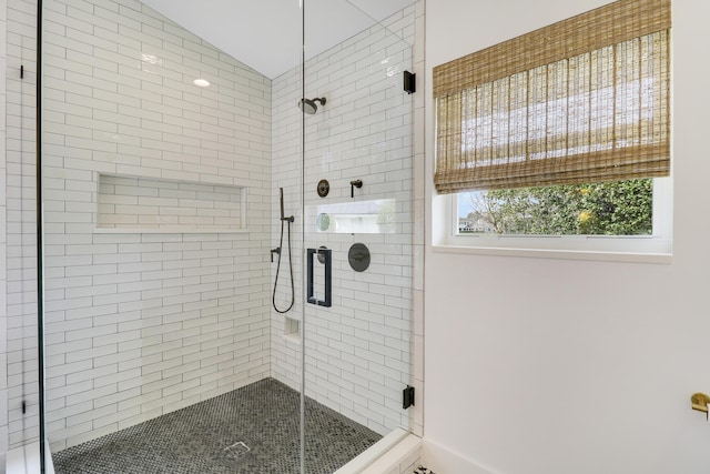 bathroom featuring vaulted ceiling and a shower with shower door