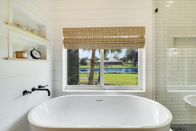 bathroom with wood walls, a water view, and a bath