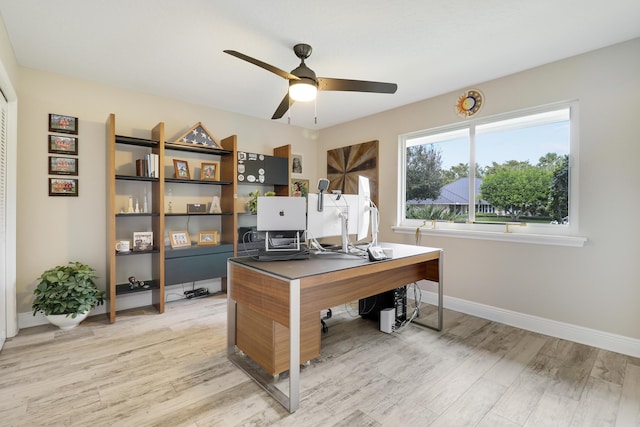 home office with light wood-type flooring and ceiling fan