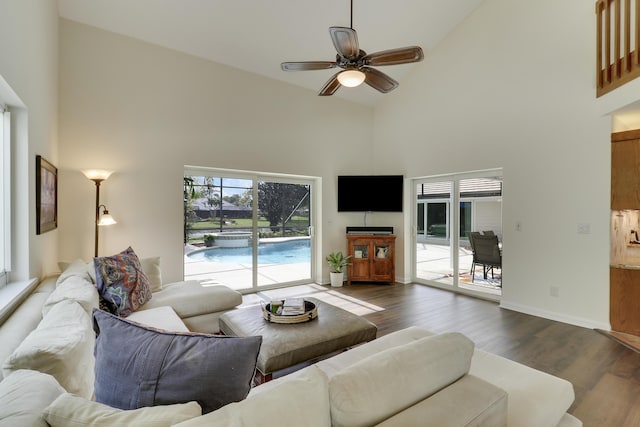 living room featuring ceiling fan, dark hardwood / wood-style floors, and high vaulted ceiling