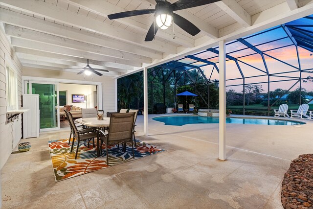 view of pool featuring a pool with connected hot tub, outdoor dining space, a patio area, ceiling fan, and a lanai