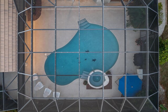 view of swimming pool featuring glass enclosure, ceiling fan, an in ground hot tub, a grill, and a patio area