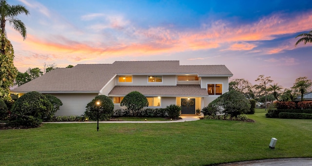 view of front of home featuring a tile roof and a front lawn