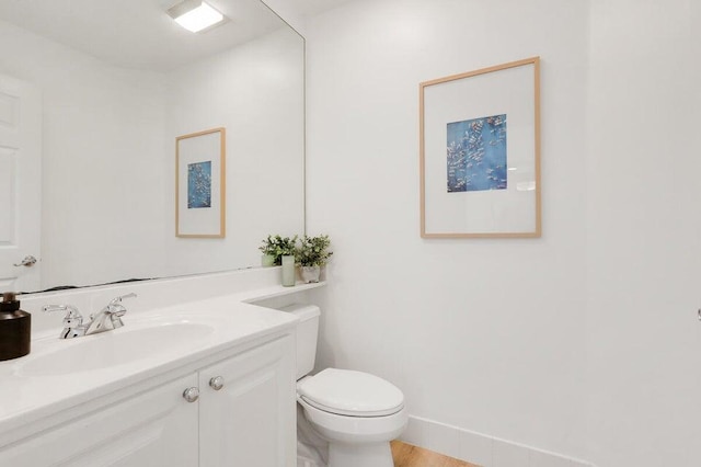 bathroom featuring vanity, wood-type flooring, and toilet