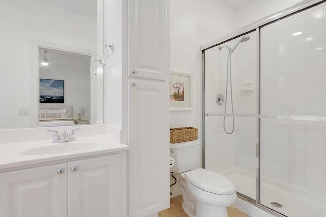 bathroom with a shower with door, vanity, and toilet