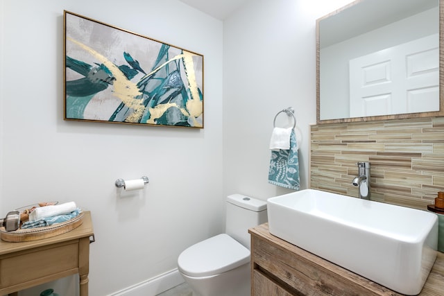 bathroom with vanity, toilet, and tasteful backsplash