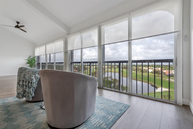 sunroom / solarium with vaulted ceiling with beams, a wealth of natural light, and ceiling fan