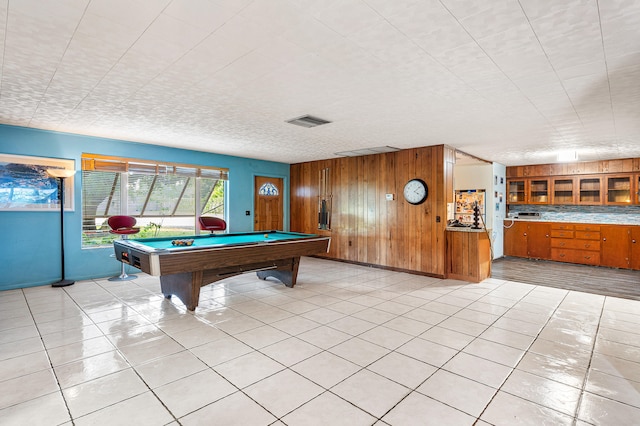 recreation room featuring wooden walls, light tile patterned floors, and billiards