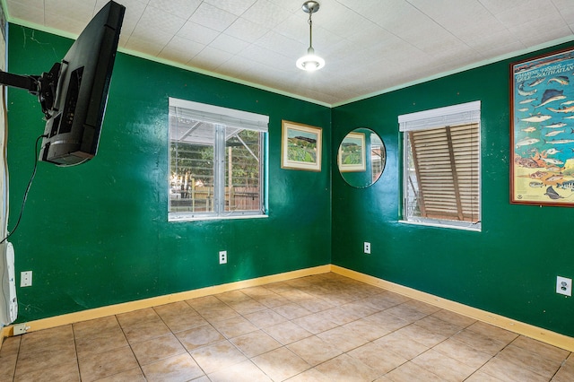 spare room featuring tile patterned flooring and ornamental molding