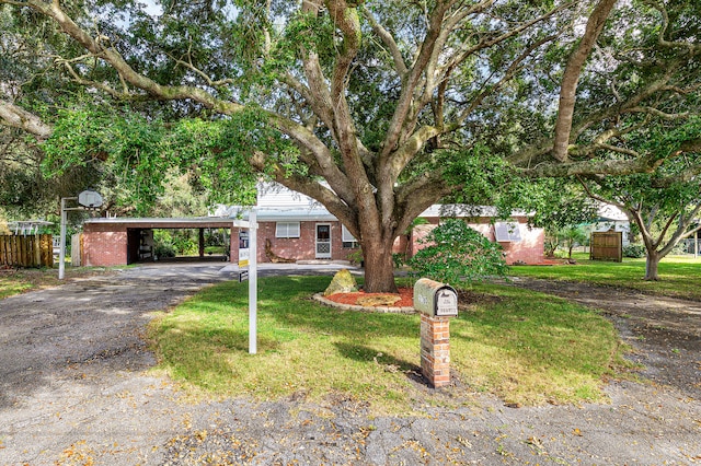 view of front of house with a front lawn and a carport