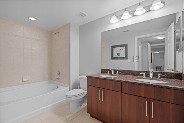 full bathroom featuring vanity, tile patterned floors, toilet, and tiled shower / bath combo