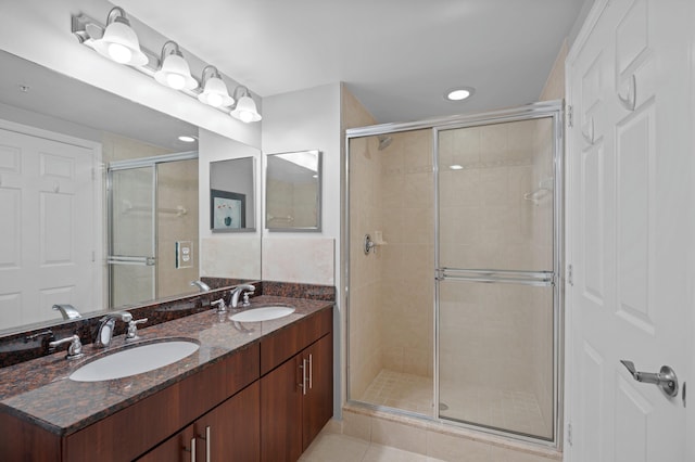 bathroom featuring tile patterned flooring, an enclosed shower, and vanity