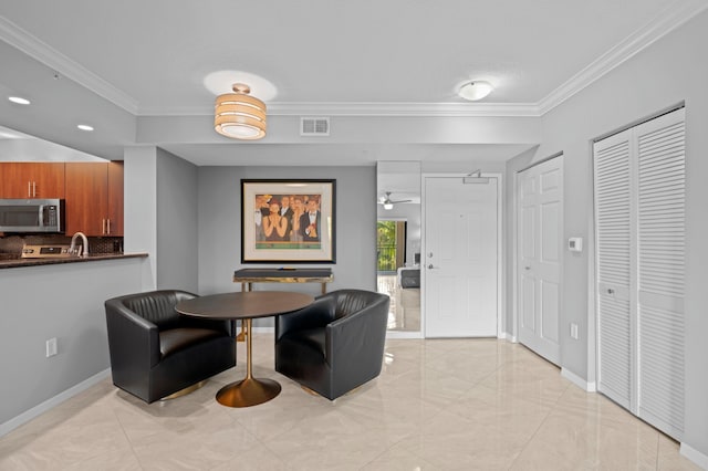 dining space with ceiling fan, sink, and ornamental molding