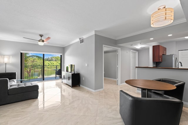 living room with ceiling fan, a textured ceiling, sink, and ornamental molding