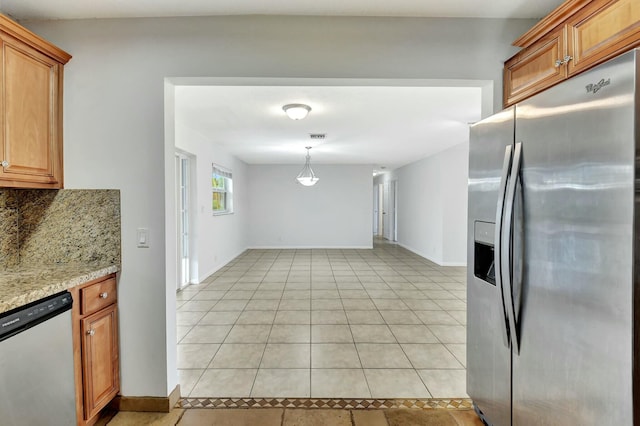 kitchen featuring hanging light fixtures, stainless steel appliances, tasteful backsplash, light stone counters, and light tile patterned floors