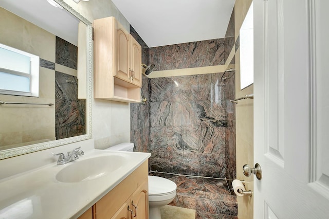 bathroom featuring tiled shower, vanity, toilet, and tile walls