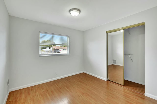 unfurnished bedroom featuring wood-type flooring and a closet