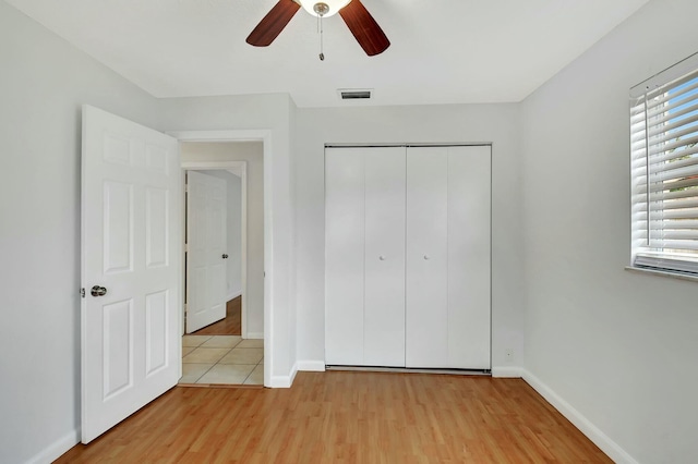 unfurnished bedroom with a closet, light hardwood / wood-style flooring, and ceiling fan