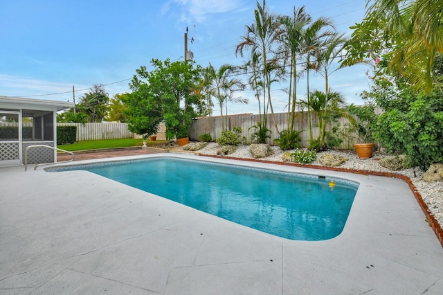 view of swimming pool featuring a patio area and a sunroom