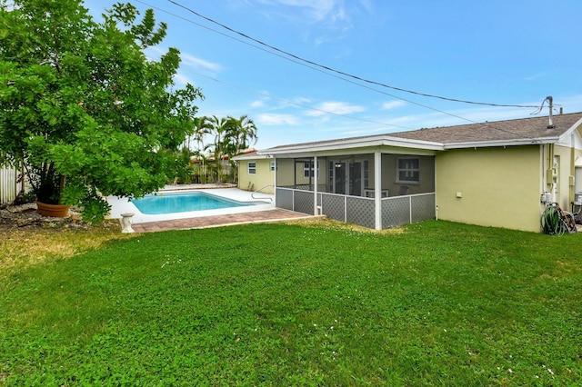 view of swimming pool with a sunroom and a lawn