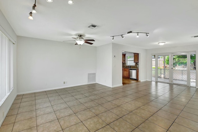 spare room featuring light tile patterned floors, rail lighting, and ceiling fan