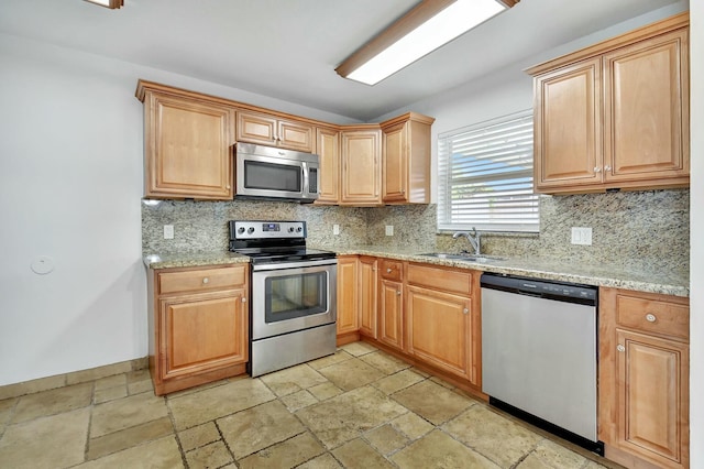 kitchen featuring decorative backsplash, light stone countertops, sink, and appliances with stainless steel finishes