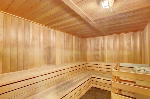 view of sauna featuring wood ceiling and wooden walls