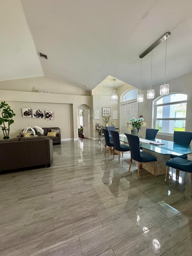 dining space featuring lofted ceiling and an inviting chandelier