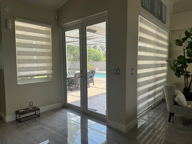 doorway featuring french doors, vaulted ceiling, and plenty of natural light