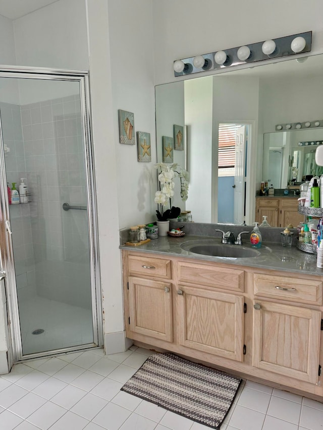 bathroom featuring tile patterned floors, vanity, and a shower with shower door