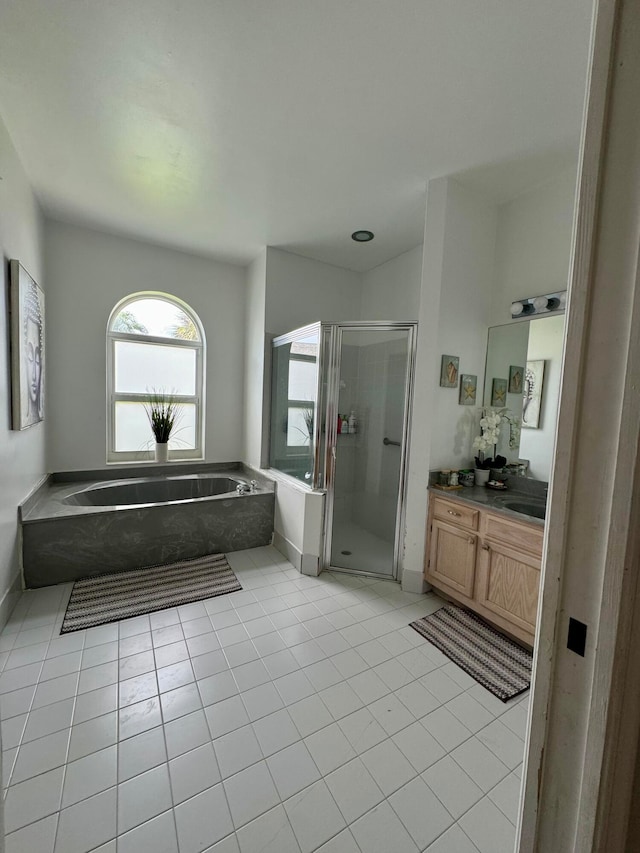 bathroom with tile patterned flooring, vanity, and shower with separate bathtub