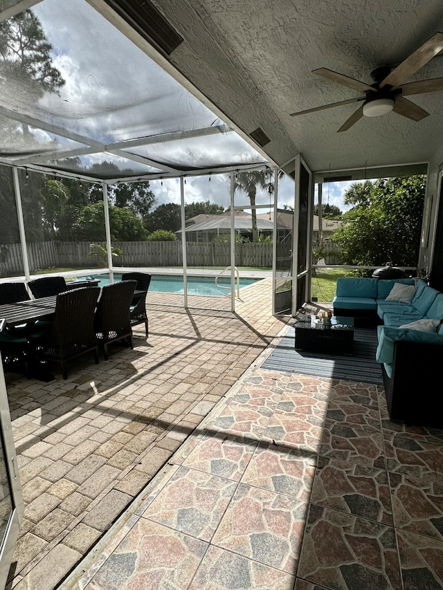 view of patio with a lanai, ceiling fan, a fenced in pool, and an outdoor hangout area