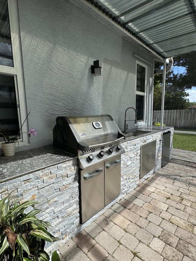 view of patio / terrace with a grill, exterior kitchen, and sink