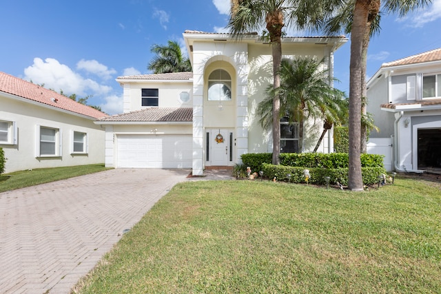 mediterranean / spanish home with a front yard and a garage