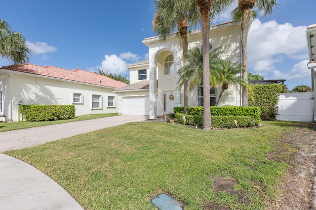 mediterranean / spanish home featuring a front yard and a garage