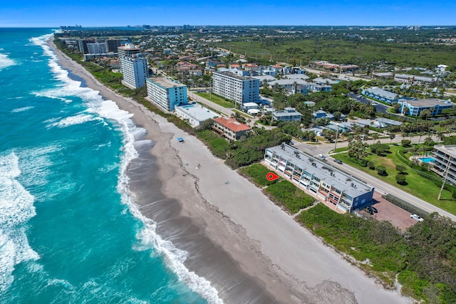 birds eye view of property featuring a water view and a beach view