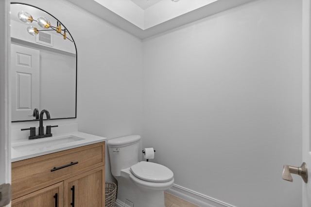 bathroom featuring vanity, hardwood / wood-style flooring, and toilet