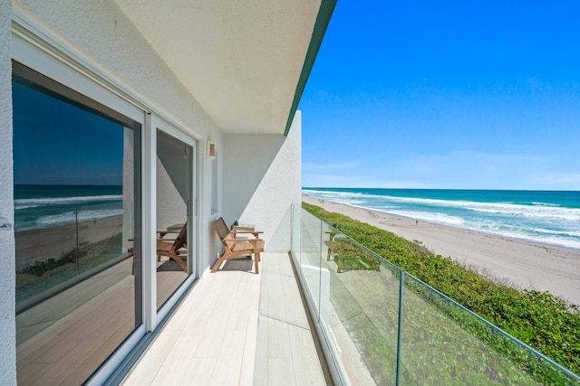 balcony with a water view and a beach view