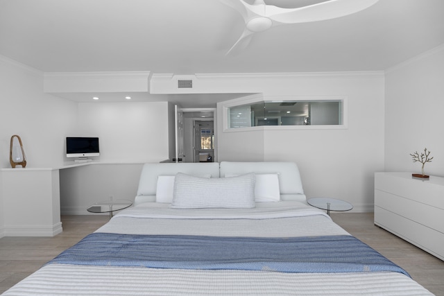 bedroom with crown molding, hardwood / wood-style flooring, and ceiling fan