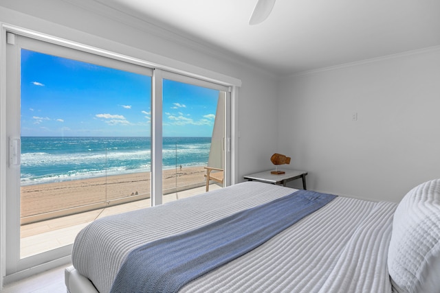 bedroom featuring multiple windows, a water view, and a beach view